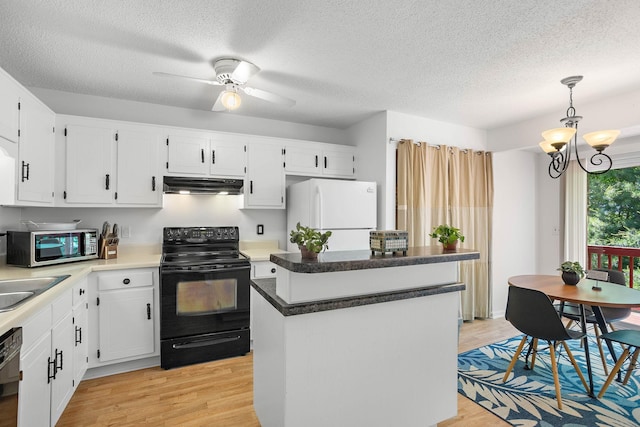 684 Dutchmans Dr, Hermitage, TN 37076 - kitchen with black appliances, under cabinet range hood, a kitchen island, light wood-style floors, and a chandelier