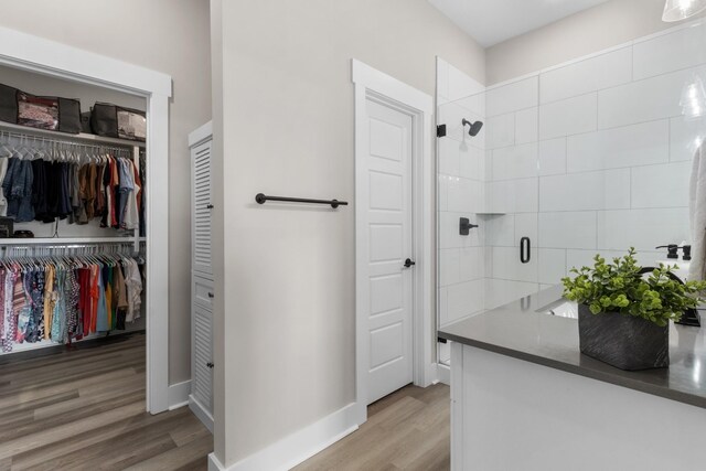 207 Charleston Ave, Pleasant View, TN 37146 - bathroom with wood finished floors, a stall shower, a spacious closet, and baseboards