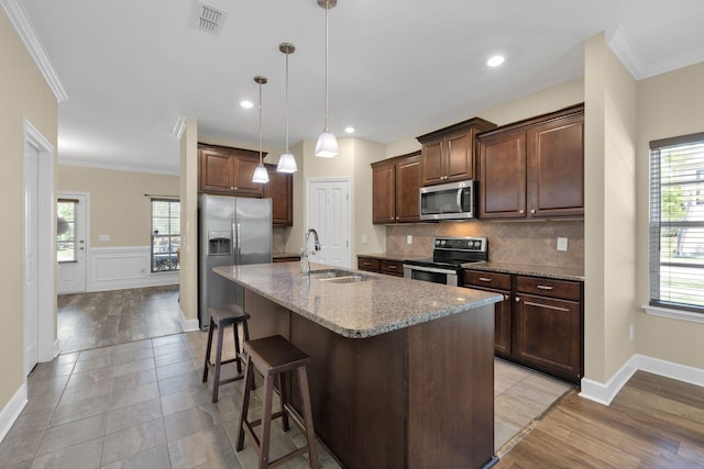 1596 Winding Creek Dr, Nolensville, TN 37135 - kitchen featuring stainless steel appliances, a sink, crown molding, a kitchen breakfast bar, and decorative backsplash