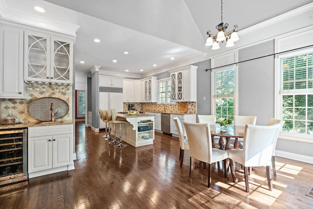 30 Park Mdws, Nashville, TN 37215 - dining area featuring wine cooler, a chandelier, bar with sink, crown molding, and dark wood-type flooring
