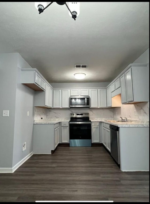 3715 Red Willow Ct, Murfreesboro, TN 37128 - kitchen with appliances with stainless steel finishes, tasteful backsplash, baseboards, and dark wood-type flooring