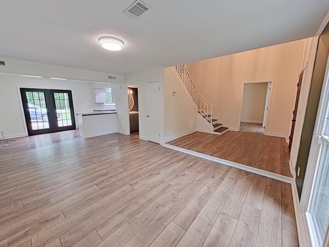 7 E Ln, Fayetteville, TN 37334 - unfurnished living room with stairs, light wood finished floors, french doors, a textured ceiling, and baseboards