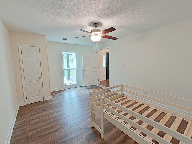 7 E Ln, Fayetteville, TN 37334 - unfurnished bedroom featuring wood finished floors, a textured ceiling, baseboards, and ceiling fan