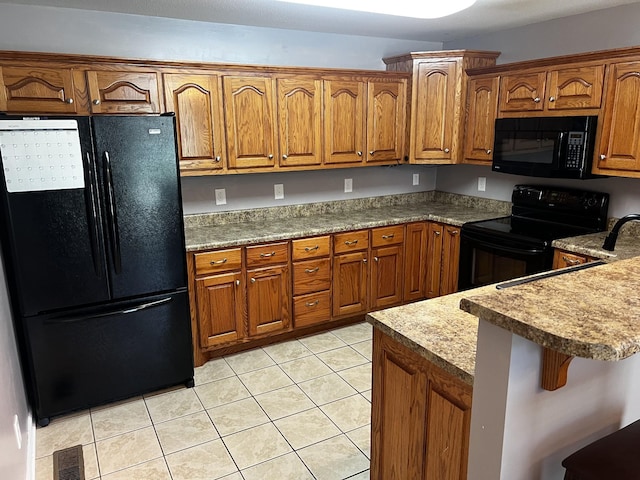168 Commodore Cir, Summertown, TN 38483 - kitchen with black appliances, brown cabinets, light tile patterned flooring, and a breakfast bar area