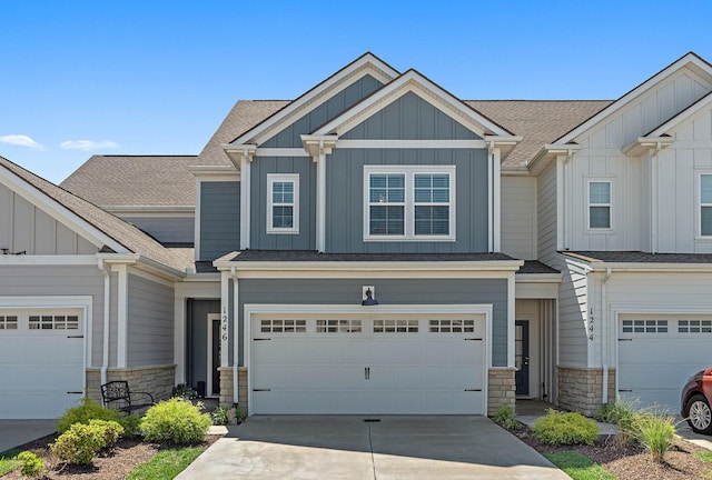 1246 June Wilde Rdg, Spring Hill, TN 37174 - view of front of home with board and batten siding, stone siding, concrete driveway, and a garage