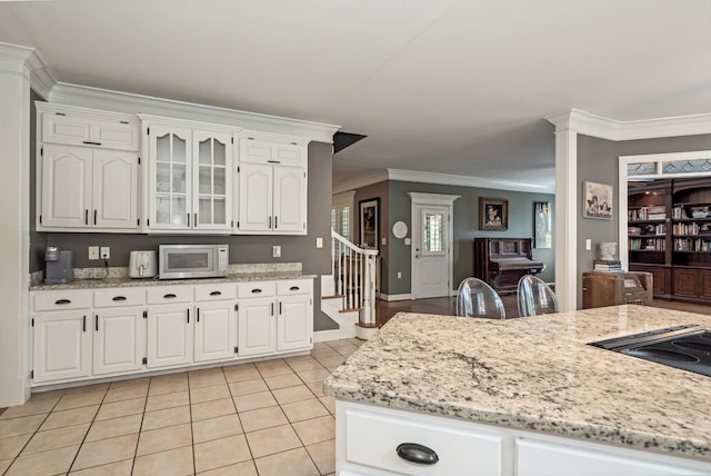 1205 Sequoya Trl, Columbia, TN 38401 - kitchen with white microwave, ornamental molding, white cabinetry, light tile patterned flooring, and light stone countertops