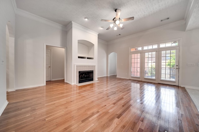 122 Belmont Cir, Hendersonville, TN 37075 - unfurnished living room featuring ceiling fan, arched walkways, light wood-style flooring, baseboards, and a tiled fireplace