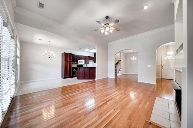 122 Belmont Cir, Hendersonville, TN 37075 - unfurnished living room with arched walkways, a chandelier, light wood-style flooring, ceiling fan, and crown molding