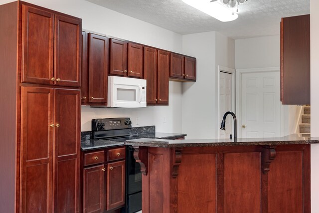 122 Belmont Cir, Hendersonville, TN 37075 - kitchen featuring white microwave, black range with electric stovetop, reddish brown cabinets, a textured ceiling, and dark stone countertops