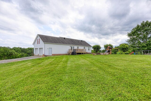 3970 Pleasant Grove Rd, White House, TN 37188 - rear view of property with a playground, gravel driveway, a garage, a wooden deck, and a lawn