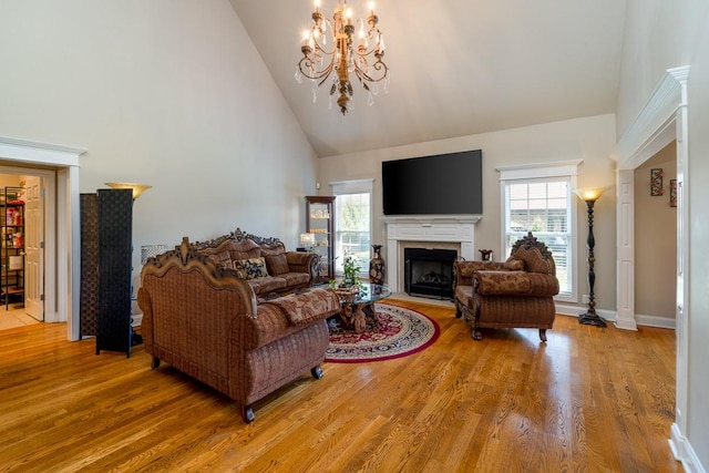 2317 Saint Andrews Dr, Murfreesboro, TN 37128 - living room featuring high vaulted ceiling, a chandelier, a fireplace with flush hearth, healthy amount of natural light, and wood finished floors