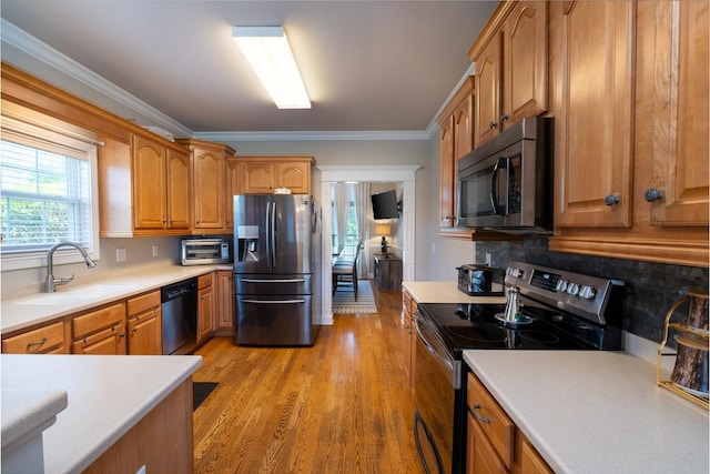 2317 Saint Andrews Dr, Murfreesboro, TN 37128 - kitchen with appliances with stainless steel finishes, decorative backsplash, ornamental molding, light countertops, and light wood-style flooring