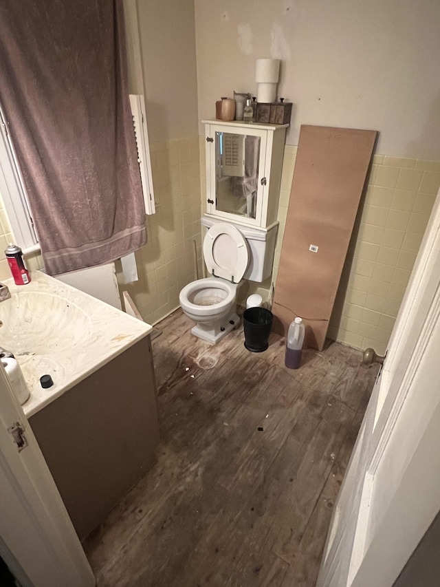 1802 Glen Oaks Ln, Dyersburg, TN 38024 - half bath featuring tile walls, vanity, toilet, wood finished floors, and a wainscoted wall