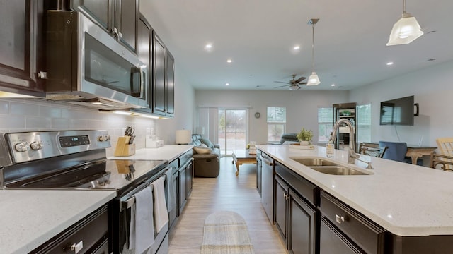 130 Keelon Gap Rd, Spring Hill, TN 37174 - kitchen with appliances with stainless steel finishes, a sink, open floor plan, a ceiling fan, and light wood-type flooring