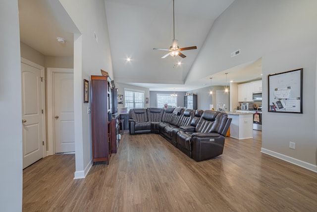 82 Pinnacle Point Ln, Tullahoma, TN 37388 - living area with wood finished floors, ceiling fan, high vaulted ceiling, a chandelier, and baseboards