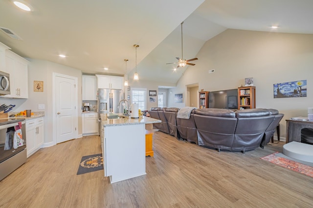 82 Pinnacle Point Ln, Tullahoma, TN 37388 - kitchen featuring stainless steel appliances, open floor plan, light wood-type flooring, a sink, and white cabinets