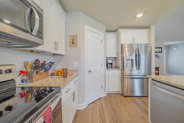 82 Pinnacle Point Ln, Tullahoma, TN 37388 - kitchen with appliances with stainless steel finishes, light wood-type flooring, white cabinets, light stone countertops, and recessed lighting