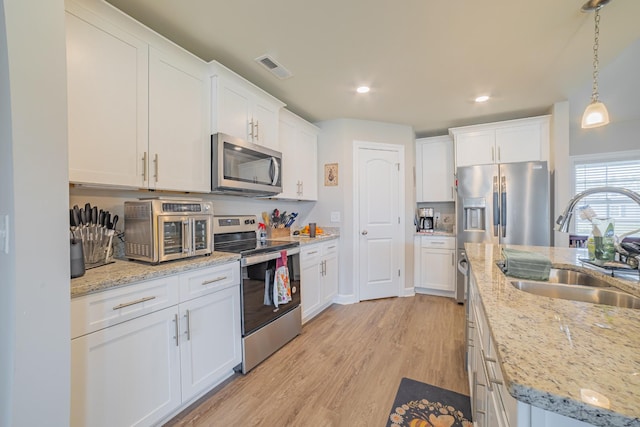 82 Pinnacle Point Ln, Tullahoma, TN 37388 - kitchen featuring stainless steel appliances, a sink, white cabinets, light wood-style floors, and recessed lighting