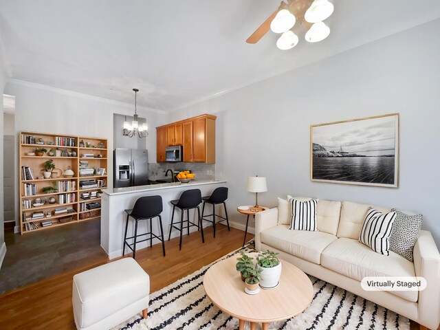 137 Dean St, Pleasant View, TN 37146 - living room featuring dark wood-type flooring, a chandelier, a ceiling fan, and ornamental molding