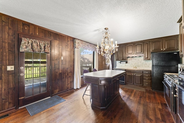 191 Green Harbor Rd, Old Hickory, TN 37138 - kitchen with stainless steel stove, a chandelier, dark wood finished floors, wooden walls, and a textured ceiling