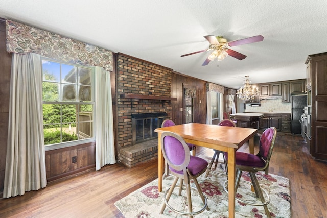 191 Green Harbor Rd, Old Hickory, TN 37138 - dining room featuring a ceiling fan, dark wood finished floors, wooden walls, a brick fireplace, and a chandelier