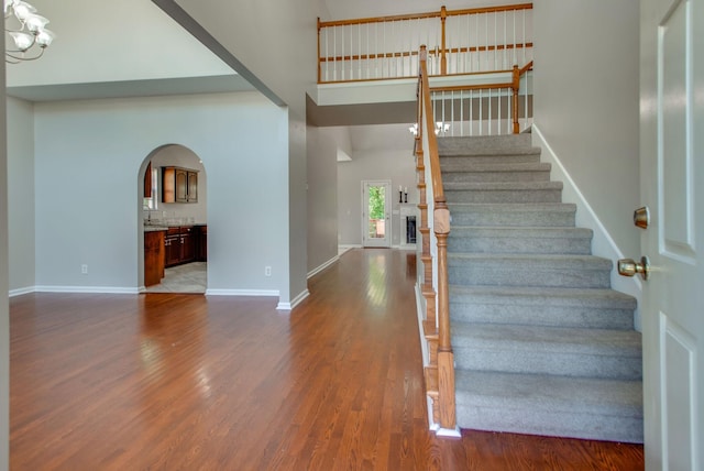 5409 Oak Chase Dr, Antioch, TN 37013 - stairs with arched walkways, wood finished floors, a towering ceiling, and baseboards