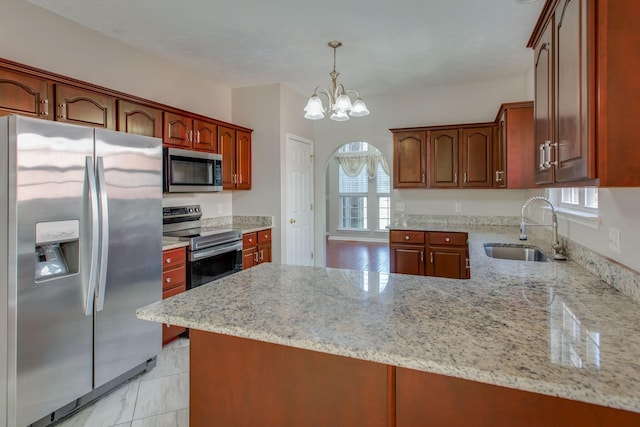 5409 Oak Chase Dr, Antioch, TN 37013 - kitchen with appliances with stainless steel finishes, a sink, a peninsula, arched walkways, and light stone counters