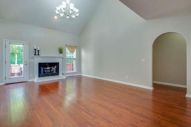 5409 Oak Chase Dr, Antioch, TN 37013 - unfurnished living room featuring plenty of natural light, a chandelier, wood finished floors, arched walkways, and high vaulted ceiling