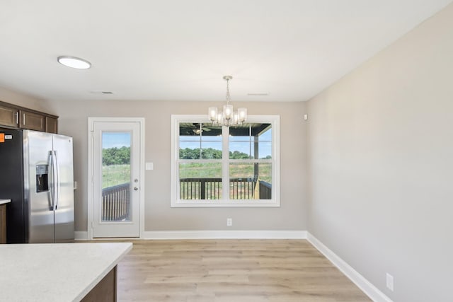 837 Macon Ln, Clarksville, TN 37042 - unfurnished dining area with plenty of natural light, a chandelier, light wood finished floors, and baseboards