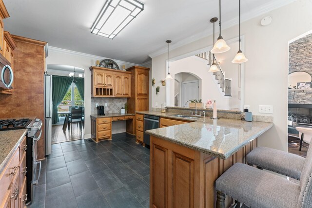 1408 Baker Ln, Lawrenceburg, TN 38464 - kitchen featuring appliances with stainless steel finishes, a sink, arched walkways, ornamental molding, and a peninsula