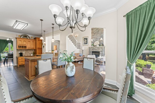 1408 Baker Ln, Lawrenceburg, TN 38464 - dining space with healthy amount of natural light, a stone fireplace, a chandelier, and crown molding