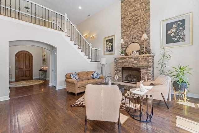 1408 Baker Ln, Lawrenceburg, TN 38464 - living area with arched walkways, a high ceiling, baseboards, wood finished floors, and a stone fireplace