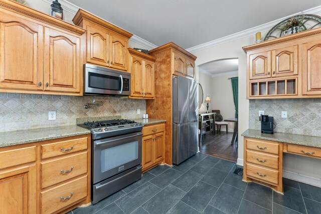 1408 Baker Ln, Lawrenceburg, TN 38464 - kitchen with stainless steel appliances, arched walkways, crown molding, light stone countertops, and decorative backsplash