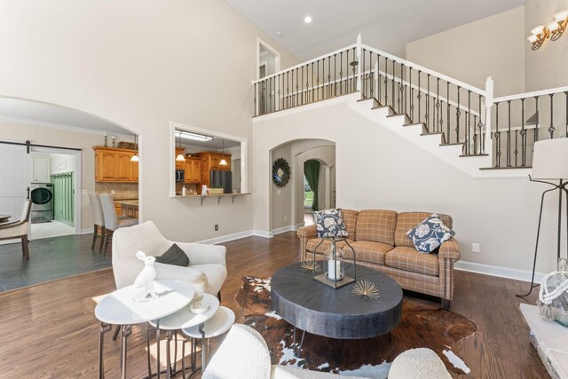 1408 Baker Ln, Lawrenceburg, TN 38464 - living room featuring arched walkways, a towering ceiling, a barn door, wood finished floors, and baseboards