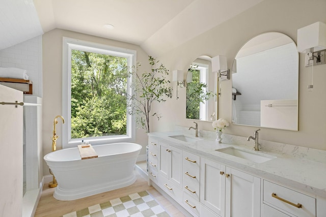 2974 W Mor Dr, Clarksville, TN 37043 - bathroom with vaulted ceiling, a freestanding bath, double vanity, wood finished floors, and baseboards