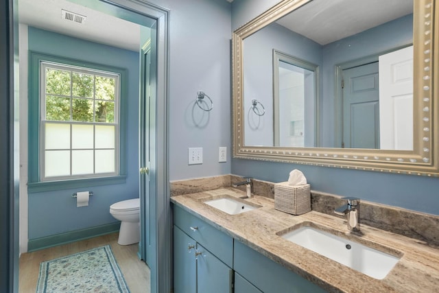 2974 W Mor Dr, Clarksville, TN 37043 - full bathroom featuring wood finished floors, toilet, double vanity, and baseboards