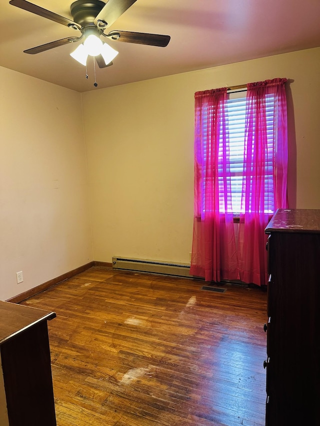 915 Wedgewood Ave, Nashville, TN 37203 - spare room featuring wood finished floors, ceiling fan, baseboards, and a baseboard radiator