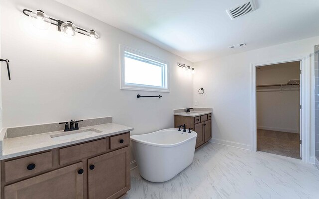 198 John T Alexander Blvd, Hendersonville, TN 37075 - bathroom featuring two vanities, a freestanding tub, a walk in closet, marble look tile flooring, and baseboards