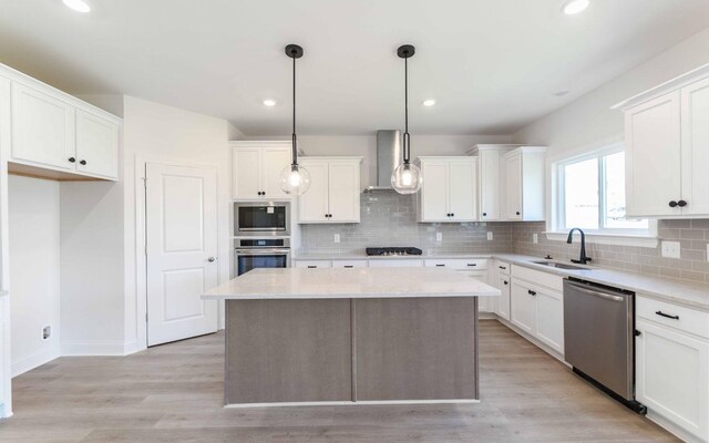 198 John T Alexander Blvd, Hendersonville, TN 37075 - kitchen featuring stainless steel appliances, wall chimney exhaust hood, a sink, a center island, and backsplash