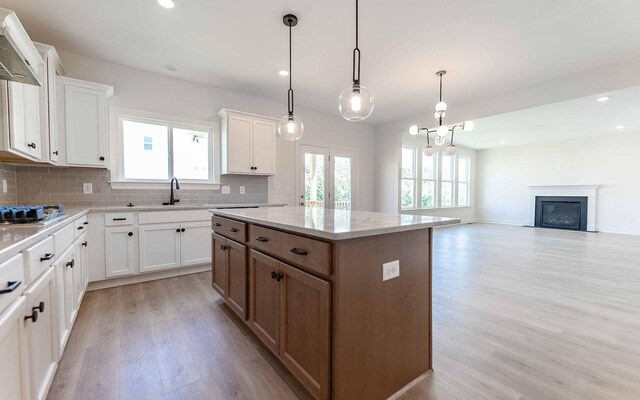 198 John T Alexander Blvd, Hendersonville, TN 37075 - kitchen with exhaust hood, light wood-style flooring, tasteful backsplash, stainless steel gas cooktop, and a kitchen island