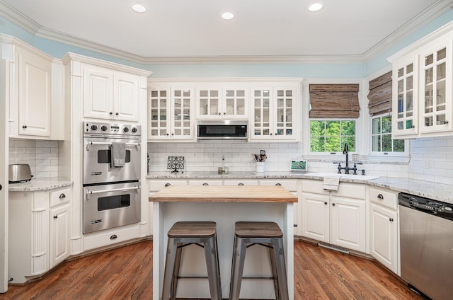 256 Scenic Dr, Dickson, TN 37055 - kitchen featuring appliances with stainless steel finishes, a sink, tasteful backsplash, white cabinetry, and ornamental molding