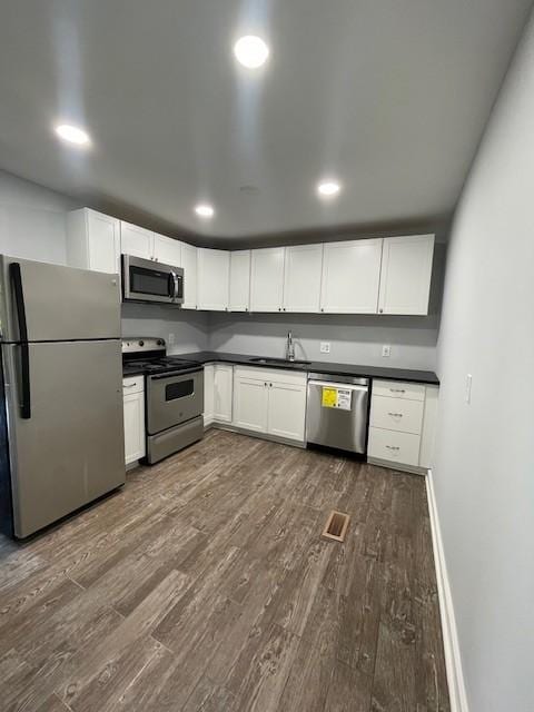 4805 Buena Vista Pike, Nashville, TN 37218 - kitchen featuring stainless steel appliances, dark countertops, dark wood-style floors, a sink, and recessed lighting