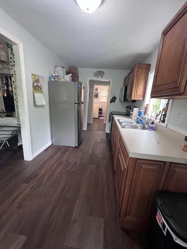 962 3rd St, Tracy City, TN 37387 - kitchen featuring stainless steel appliances, light countertops, a textured ceiling, dark wood-type flooring, and a sink