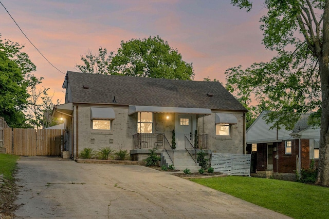 1607 Riverside Dr, Nashville, TN 37216 - view of front of house featuring brick siding, covered porch, concrete driveway, a shingled roof, and a gate