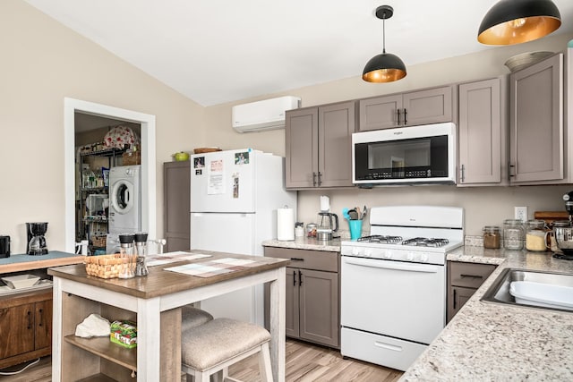 3269 Moodyville Rd, Byrdstown, TN 38549 - kitchen featuring white appliances, a wall mounted air conditioner, stacked washing machine and dryer, gray cabinetry, and light wood-type flooring