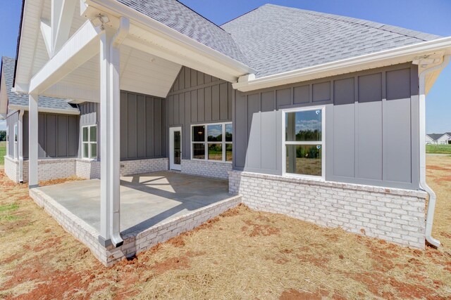 296 Lookout Dr, Winchester, TN 37398 - back of property with board and batten siding, a patio, roof with shingles, and brick siding