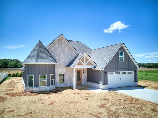 296 Lookout Dr, Winchester, TN 37398 - view of front of home with board and batten siding, driveway, brick siding, a shingled roof, and an attached garage