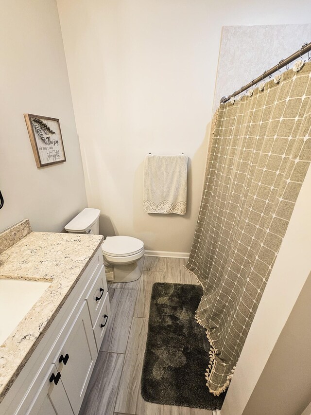 300 Woodson Dr, Tullahoma, TN 37388 - full bathroom featuring vanity, toilet, curtained shower, and wood finished floors