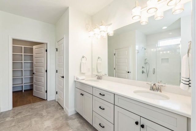 611 Lake Reserve Cv, Hermitage, TN 37076 - bathroom featuring a stall shower, double vanity, a walk in closet, and baseboards
