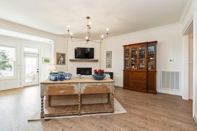 611 Lake Reserve Cv, Hermitage, TN 37076 - living room featuring a brick fireplace, a chandelier, crown molding, wood finished floors, and baseboards